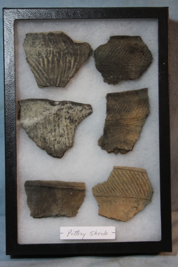 Native American pottery shards and bone tools, framed