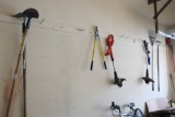 Assorted hand tools on wall and in corner