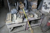 Table with saw, two buffing machines and other items on top