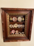 Antique frame filled with miniature porcelain pieces