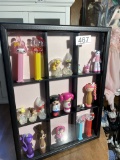 Display case with small toys including Pez