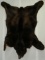Black bear rug with hangers for wall mount ability, showing wear to one ear, measuring 68