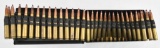 .50 BMG ammunition in metal storage container having red and silver painted tips.