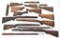 Grouping of assorted rifle and shotgun stocks in various conditions showing varying degrees of wear.