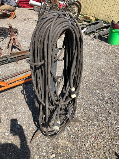 Approximately hundred foot extension cord. On metal stand.