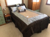 Full mattress, comforter, table and lamp.