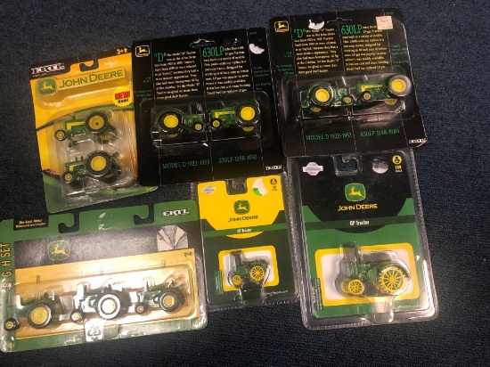 Six packages of unopened John Deere miniature diecast tractors