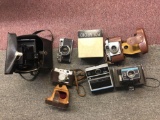 Two boxes of vintage cameras including Polaroid, Sears, and thimbles