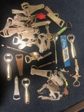 Collection of vintage metal bottle openers with various advertising on them