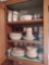 Contents of kitchen cabinet including glass basket, meat grinder, tumblers, dish set, flatware