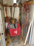 Bay of yard tools, jumper cables, and cart