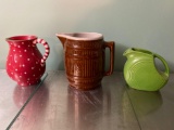 Fiesta green pitcher, barrel pattern brown pitcher, holiday pitcher.