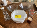 Corning covered dish, Pyrex measure, vinegar/oil bottles, scented candle, bowls.