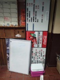 Small Rubbermaid cooler, menu board, whiteboard and two posters