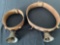 Two old brass bells on leather collars.