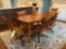 Solid wood dining table with 6 chairs on casters and 1 extra leaf and pads