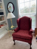 Claw foot wing back chair, brass and glass top side table, with brass lamp, oval mirror