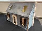 Blue wood-sided dollhouse with furniture