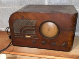 Silvertone radio. Piece of veneer missing on speaker, needs cleaned.
