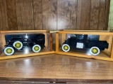 Two model cars in wood display boxes.