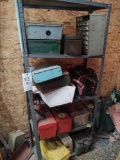 Metal shelf with assorted camp stoves and toolboxes