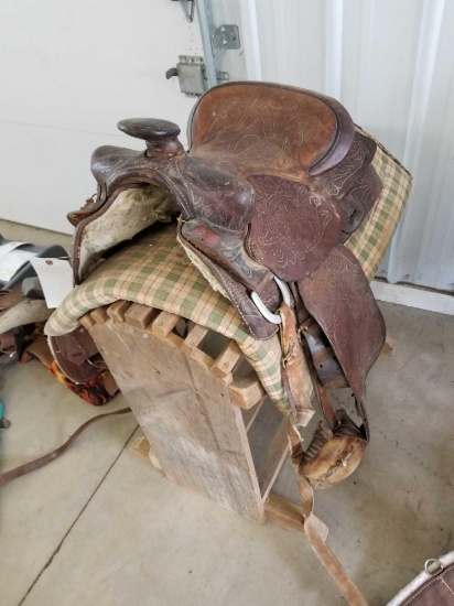 Western saddle with blanket and wood stand