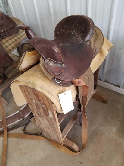 Western saddle with blanket and wood stand