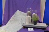 Comfy at home basket that includes a riser, three piece candle holder,