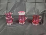 3 cranberry pitchers footed