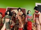 Eight Japanese geisha dolls 14 to 18 inches tall