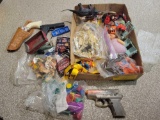 Box lot of assorted toy guns, plastic toys and cars, figures and dinosaur bones