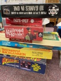 Stack of vintage board games including Monopoly, Backgammon, poker, railroad