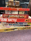 Stack of vintage board games including Uncle Wiggly, Jumanji, RISK, etc.