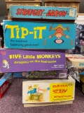 Stack of vintage board games including Tippit, Straight Arrow, Five Little Monkeys, etc.