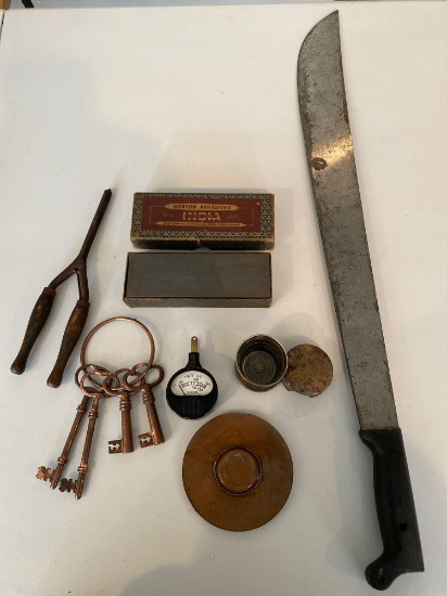 Norton sharpening stone, keys, hair curler, machete, volt meter