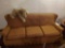 Orange Cushioned Sleeper Sofa with Stuffed Puppy
