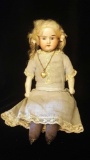 Antique porcelain doll with blonde hair and paperweight blue eyes
