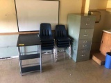 Nine stacked chairs, metal file cabinet and small desk