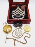 Small showcase with military items: wings pin, US compass, patch, watch chain