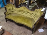 green upholstered craved wood setee