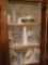 Contents of kitchen cupboards top and bottom of cabinets, china, mugs, jars, casserole dishes, and