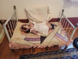 Early metal doll bed with unmarked porcelain head doll