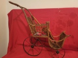 Early bent wood Victorian style baby buggy with metal wheels