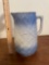 Blue and white stoneware pitcher with floral and basketweave pattern