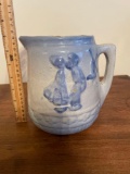 Blue and white stoneware pitcher with boy and girl