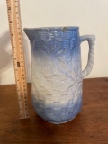 Blue and white stoneware pitcher with floral and basketweave pattern