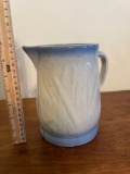 Blue and white stoneware pitcher with cattails