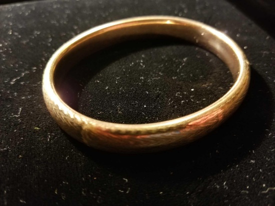 Unmarked lady's yellow oval bangle bracelet with machine engraving.