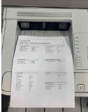 desktop laser printers with test pages printed out to verify print quality.