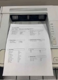 desktop laser printers with test pages printed out to verify print quality.